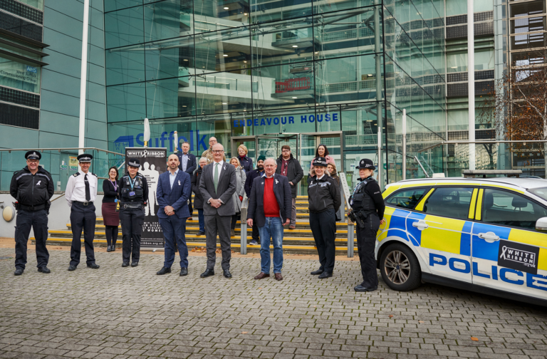 group photo outside Endeavour House, of Suffolk County and other partner agencies standing together for White Ribbon Day after signing the pledge